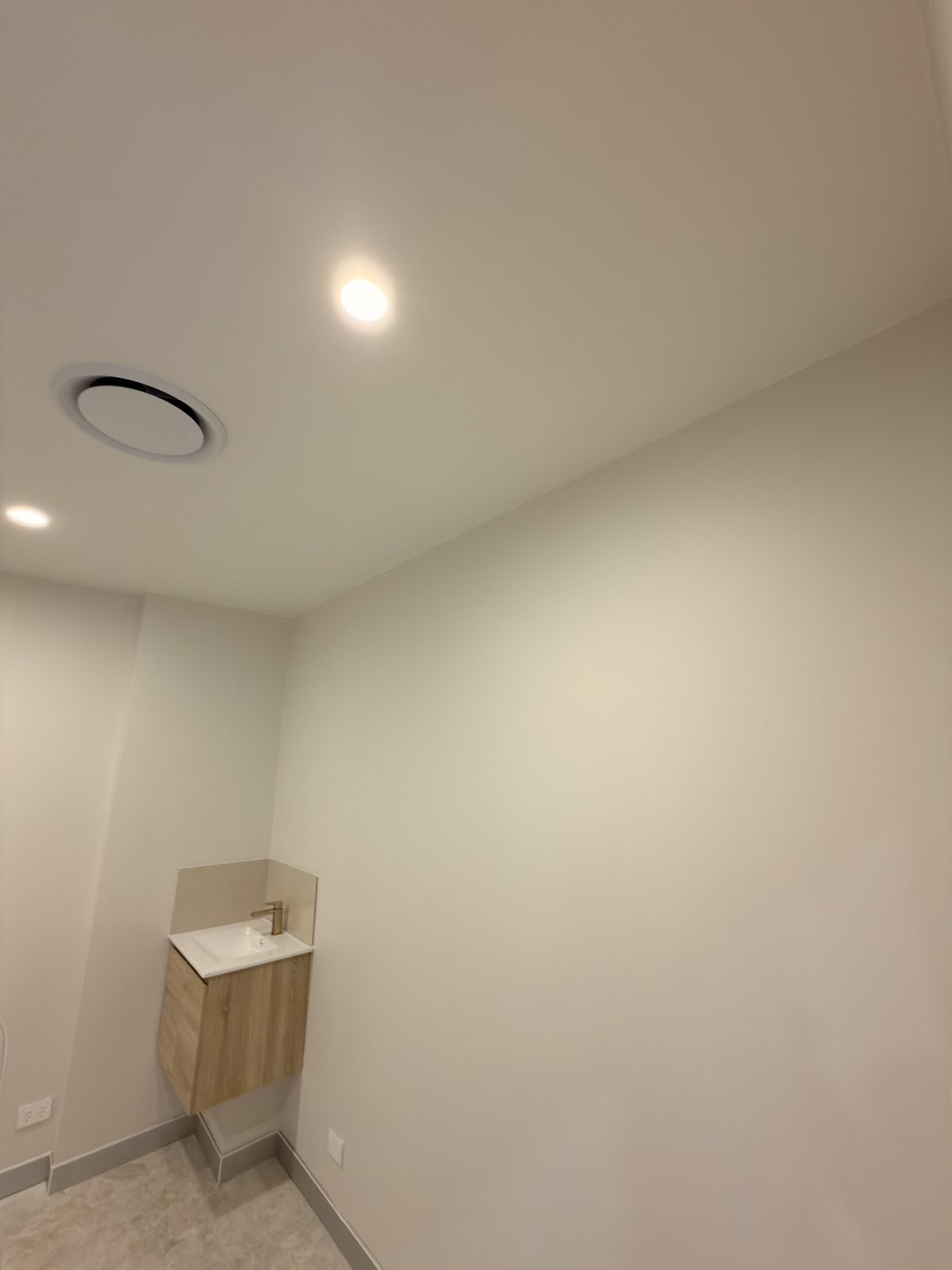 A treatment room with vanity, showing the finished wall and ceiling work